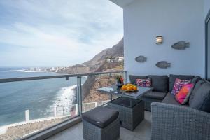 a living room with a couch and a view of the ocean at In Tenerife, luxury apartment overlooking the Atlantic in Bajamar