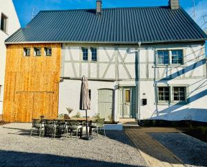 a house with a table and chairs and an umbrella at Gude Zeit Ferienhaus in Mörsdorf