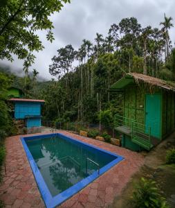 ein Haus mit Swimmingpool neben einem Wald in der Unterkunft Bambooleaf pool dormitory in Meppādi