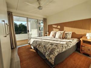 a bedroom with a bed and a large window at Ocean Whisper Beach Villas in Jeffreys Bay