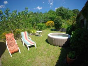 a couple of chairs and a tub in a yard at Balocco Countryside Home 1908 - Barga in Sommocolonia