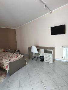 a bedroom with a bed and a tv on the wall at Cibali rooms in Catania