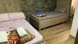 a room with two beds and a couch at Natura Koman in Koman +3 photos