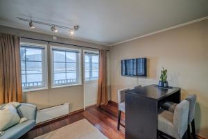 a living room with a desk and chairs and windows at Hustadvika Havhotell - by Classic Norway Hotels in Farstad