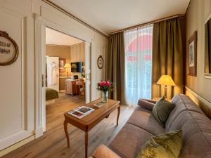 a living room with a couch and a table at Carlton Lausanne Boutique Hôtel in Lausanne