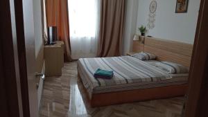 ein Schlafzimmer mit einem Bett und einem Fernseher in der Unterkunft FabiRooms in Bukarest