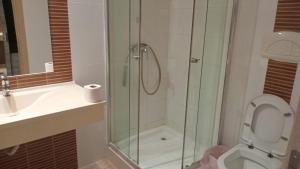 ein Badezimmer mit Dusche, Toilette und Waschbecken in der Unterkunft FabiRooms in Bukarest