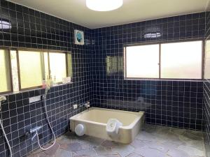 a blue tiled bathroom with a bath tub at ロッジ星の時間 Lodge in Hokuto +26 photos