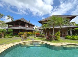 a house with a swimming pool in front of a house at Hotel Bunga Permai in Ubud