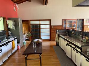 a large kitchen with a table in the middle at ロッジ星の時間 Lodge in Hokuto