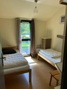 a bedroom with two beds and a window at Domaine Aigoual Cevennes in Meyrueis +35 photos
