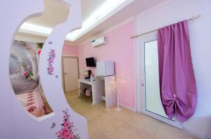 a room with a pink room with a mirror at Le corti di Elena Martina in Miggiano