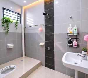 a bathroom with a shower and a toilet and a sink at Homestay nakhoda Sitiawan in Lumut +16 photos