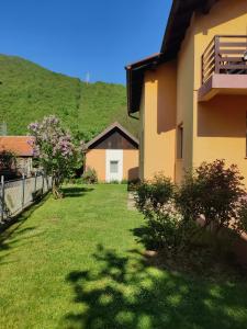 a yard of a house with a hill in the background at Vrelo Bosne 10 in Vrelo Bosne
