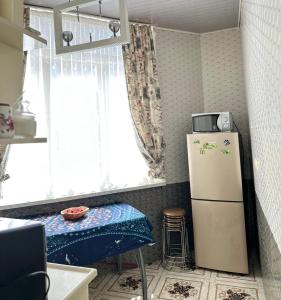 a kitchen with a refrigerator and a table and a window at Batumi in Stantsiya Batumi-Passazhirskaya +4 photos