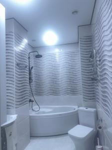 a white bathroom with a tub and a toilet at Batumi in Stantsiya Batumi-Passazhirskaya