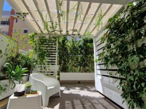a garden room with a white chair and plants at B&B Home3 bed in Bisceglie