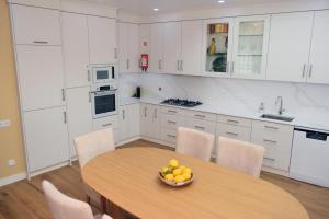 a kitchen with a wooden table with a bowl of fruit on it at Paradisus III in São Martinho do Porto