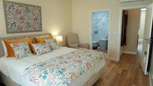 a bedroom with a large bed and a bathroom at Paradisus III in São Martinho do Porto