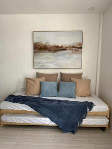 ein Bett in einem Zimmer mit einem Gemälde an der Wand in der Unterkunft The Beachfront Bataan in Morong + 2 Fotos