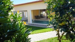 a house with a swimming pool in a yard at Paradisus III in São Martinho do Porto +4 photos