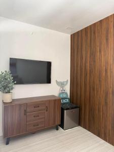 ein Wohnzimmer mit einem Fernseher an der Wand in der Unterkunft The Beachfront Bataan in Morong