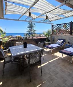 a patio with a table and chairs and a view of the ocean at Terrazza Enjoy in Letojanni
