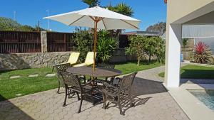 a table and chairs with an umbrella on a patio at Paradisus III in São Martinho do Porto
