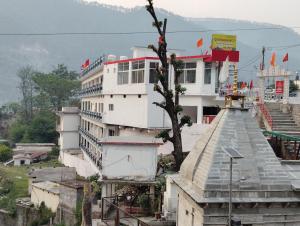 a white building with a tree on top of it at cp residency in Karnaprayāg