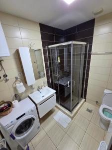 a bathroom with a shower and a washing machine at Apartman Jezdić in Banja Koviljača
