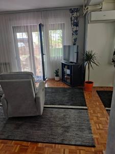 a living room with a couch and a television at Vrelo Bosne 10 in Vrelo Bosne