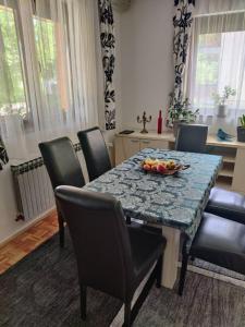 a dining room table with a bowl of fruit on it at Vrelo Bosne 10 in Vrelo Bosne