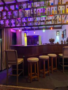 a bar with stools in a room with purple lights at Farm House Villa in Ratnapura