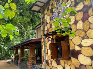 a stone building with a window and a plant at Farm House Villa in Ratnapura