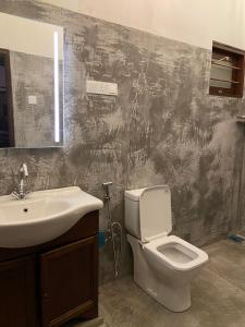 a bathroom with a toilet and a sink at Farm House Villa in Ratnapura