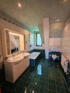 a bathroom with two sinks and a tub and a toilet at Hotel Kärntnerhof Velden - Zum Schankbaron in Velden am Wörthersee