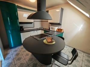 a kitchen with a black table and some chairs at Hotel Kärntnerhof Velden - Zum Schankbaron in Velden am Wörthersee