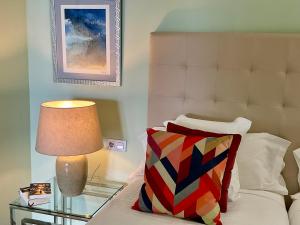 a bedroom with a bed with a lamp and a pillow at In Tenerife, luxury apartment overlooking the Atlantic in Bajamar