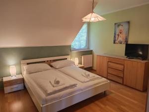 a bedroom with a bed and a flat screen tv at Hotel Kärntnerhof Velden - Zum Schankbaron in Velden am Wörthersee