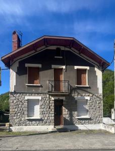 a small stone house with a porch and a balcony at Le Quai Confort T2 - in Ax-les-Thermes