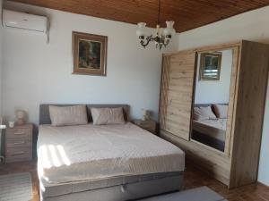 a bedroom with a bed and a large mirror at Vrelo Bosne 10 in Vrelo Bosne