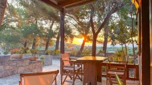 Ein Tisch und Stühle auf einer Terrasse mit Blick auf den Sonnenuntergang in der Unterkunft Stella's Traditional Inn in Káto Zákros
