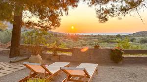 eine Terrasse mit Tisch und Stühlen und ein Sonnenuntergang in der Unterkunft Stella's Traditional Inn in Káto Zákros
