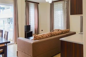 a living room with a couch and a television at Hotel Alba in Shëngjin