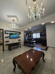 a living room with a table and a chandelier at Toum's Apartments in Amman
