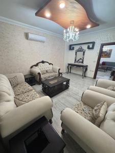 a living room with couches and a chandelier at Toum's Apartments in Amman