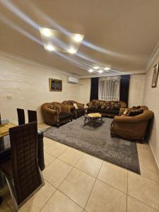 a large living room with couches and a table at Toum's Apartments in Amman