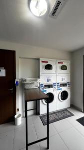 a laundry room with two washing machines and a table at Suíte Premiere in Rio de Janeiro