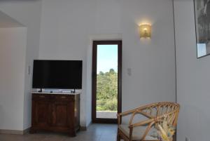 a living room with a television and a window at A Casetta d'Armonio in Piana
