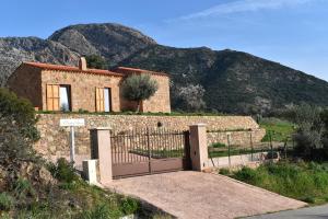 a house with a gate in front of a mountain at A Casetta d'Armonio in Piana